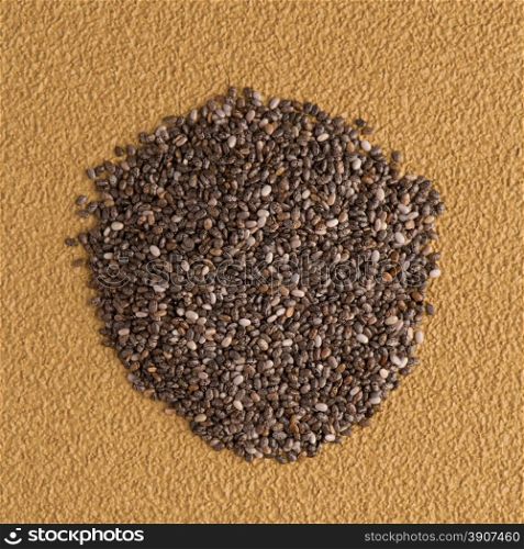 Top view of chia seeds against yellow vinyl background.