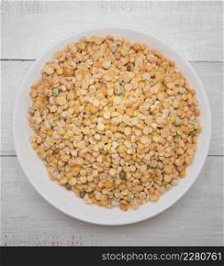 Top view of chickpeas in a bowl on wooden background