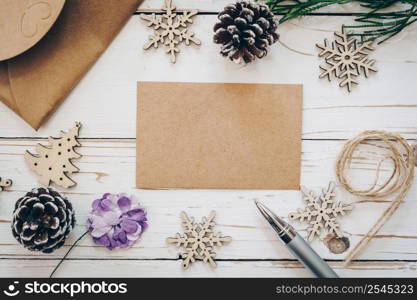 Top view of christmas card on wooden table with xmas decoration.