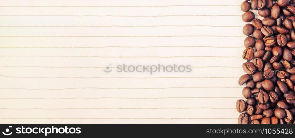 Top view of coffee beans on lined paper background and copy space for notes with retro filter effect, banner style for text