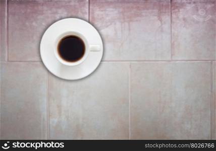 Top view of coffee cup on ceramic tiles wall texture background