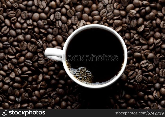 Top view of coffee cup on coffee beans