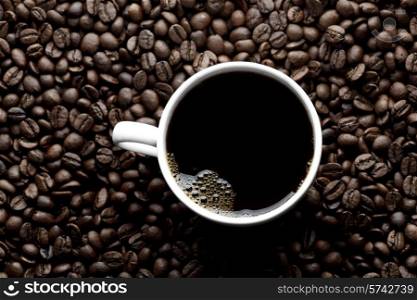 Top view of coffee cup on coffee beans