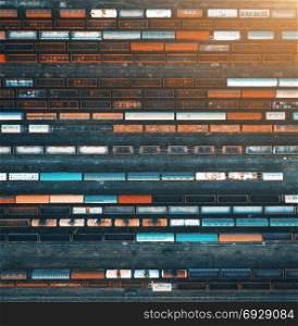 Top view of colorful cargo trains. Aerial view from flying drone of colorful freight trains on the railway station. Wagons with goods on railroad. Heavy industry. Industrial conceptual scene. Vintage