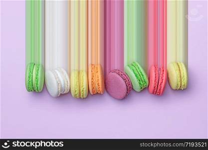 Top view of colorful macaron biscuits in a row on pastel color block background, flat lay, pixel stretch