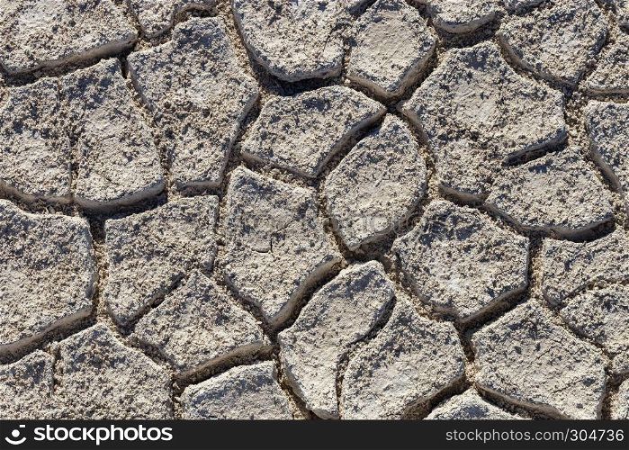 Top view of Cracked earth soil texture background. Salt desert cracks on ground with light color. Cracked earth soil texture background with light color
