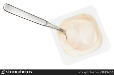 top view of creamy yoghurt and spoon in disposable plastic cup isolated on white background