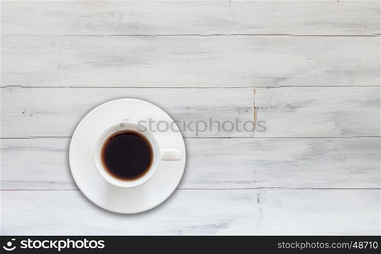 Top view of cup of fresh espresso on white wooden background