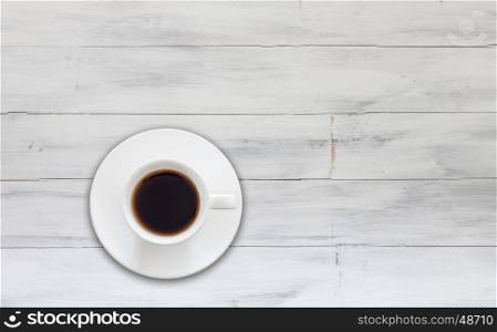 Top view of cup of fresh espresso on white wooden background