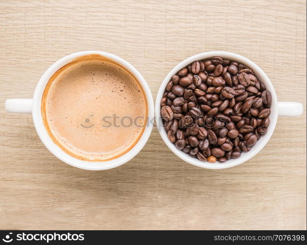 Top view of cup of latte and cup of coffee bean on wooden table background