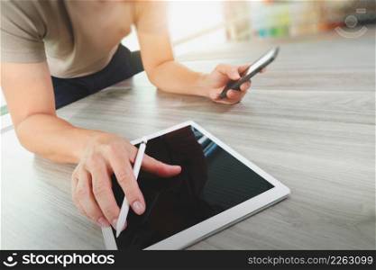 top view of Designer hand working with digital tablet computer and smart phone on wooden desk as responsive web design concept