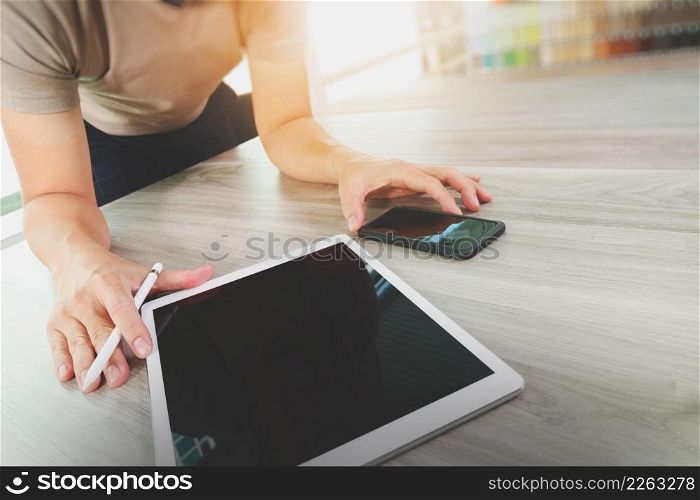 top view of Designer hand working with digital tablet computer and smart phone on wooden desk as responsive web design concept