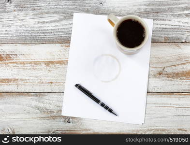 Top view of desktop with paper, pen and coffee to include stain