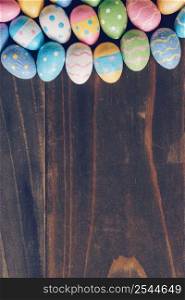 Top view of Easter eggs on rustic wood background vertical with copy space
