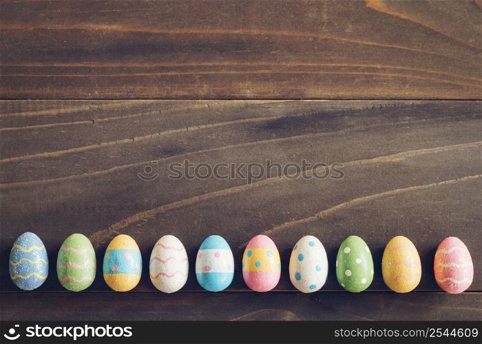 Top view of Easter eggs on rustic wood background with copy space