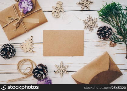 Top view of empty christmas card on wooden table with xmas decoration.