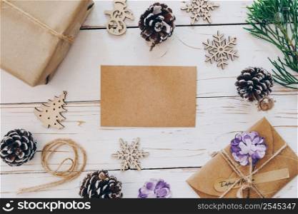 Top view of empty christmas card on wooden table with xmas decoration.