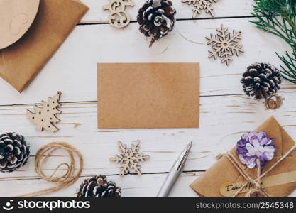 Top view of empty christmas card on wooden table with xmas decoration.