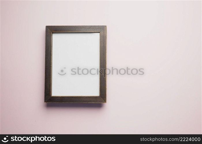 top view of empty frame on wooden background .