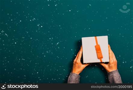 top view of female hands holding Christmas gift