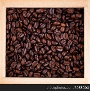 Top view of freshly roasted coffee beans in wooden box.