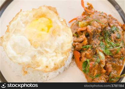 top view of fried egg over rice and pork fried with chili pepper and curry sauce