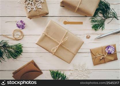 Top view of gift box and christmas card on wooden table with xmas decoration.