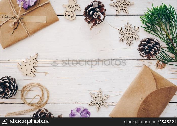 Top view of gift box and christmas card on wooden table with xmas decoration.