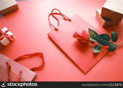 Top view of gift box and rose flower on red background .. Top view of gift box and rose flower on red background 
