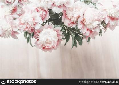 Top view of glorious pastel pink bouquet of peonies on wooden floor background. Cozy home.