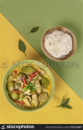 top view of green chicken curry served with rice vermicelli. green chicken curry served with rice vermicelli