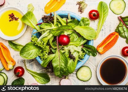 Top view of green Healthy salad bowl with dressing and ingredients, close up. Diet eating, Vegetarian or vegan food concept