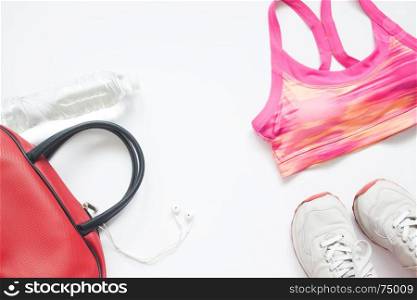 Top view of gym and fitness fashion items in pink and red collection on white background, Healthy lifestyle