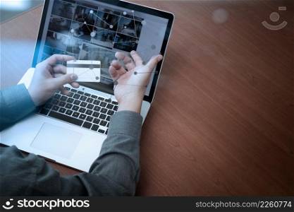 top view of hands using laptop and holding credit card with social media diagram as Online shopping concept