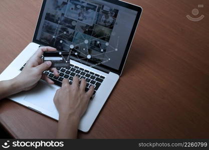 top view of hands using laptop and holding credit card with social media diagram as Online shopping concept