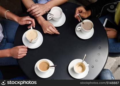 Top view of hands with coffee cups on table in a urban cafe.