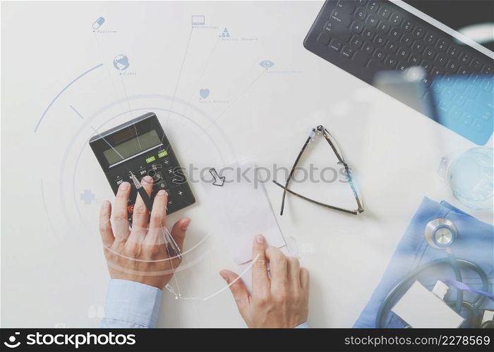 top view of Healthcare costs and fees concept.Hand of smart doctor used a calculator for medical costs in modern hospital with VR icon diagram