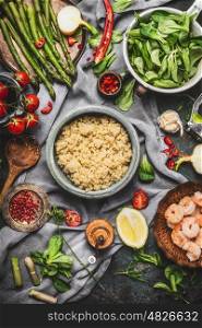 Top view of Healthy salad with asparagus and cooked quinoa seeds, preparation on rustic background with various organic vegetables. Vegetarian food and diet concept