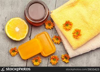 Top view of honey soap with lemon over wooden table