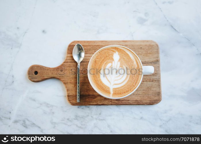 Top view of hot latte coffee on wooden tray on marble table background