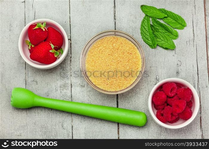 Top view of ingredients for a cocktail with berries over wooden table