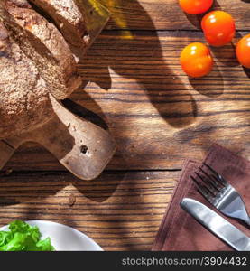 Top view of italian food on wooden table - bread, olive oil and tomatos with basil