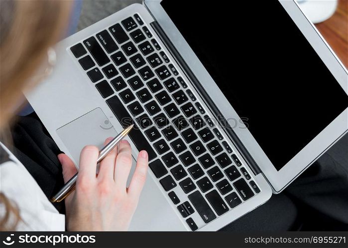 top view of laptop and female hands while working
