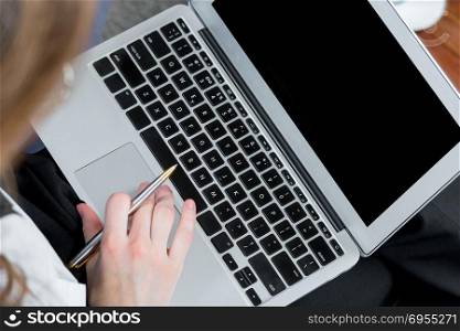 top view of laptop and female hands while working