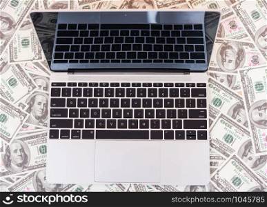 Top view of laptop computer on dollar money, finance investment currency money concept