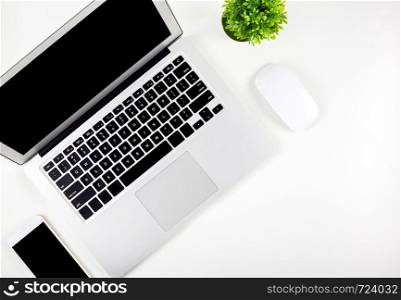 Top view of laptop computer with open display screen monitor, mouse and smart mobile phone and tree isolated on white background, communication technology on work office concept.