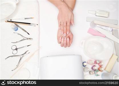 top view of manicure tools and Woman Preparing her hands for getting manicure procedure.. top view of manicure tools and Woman Preparing her hands for getting manicure procedure