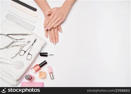 top view of manicure tools set for nail care over light background - brush, scissors, nail polish, file and tweezers.. top view of manicure tools set for nail care over light background - brush, scissors, nail polish, file and tweezers
