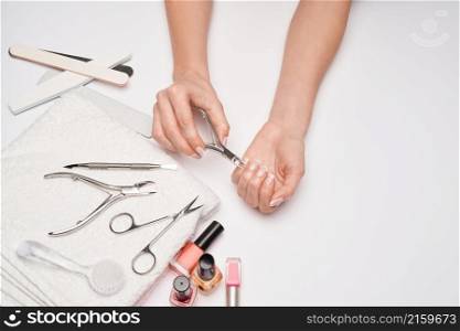 top view of manicure tools set for nail care over light background - brush, scissors, nail polish, file and tweezers.. top view of manicure tools set for nail care over light background - brush, scissors, nail polish, file and tweezers