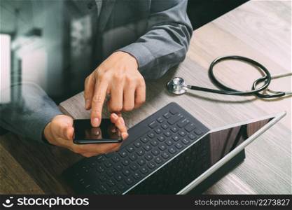 top view of medical doctor hand working with smart phone,digital tablet computer,stethoscope eyeglass,on wooden desk,filter